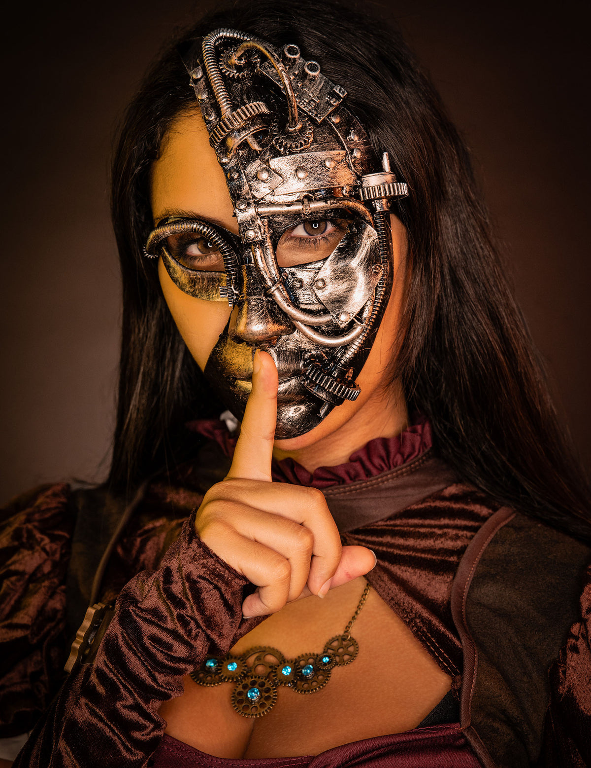 Gros plan du demi masque robot Steampunk porté avec un geste de silence