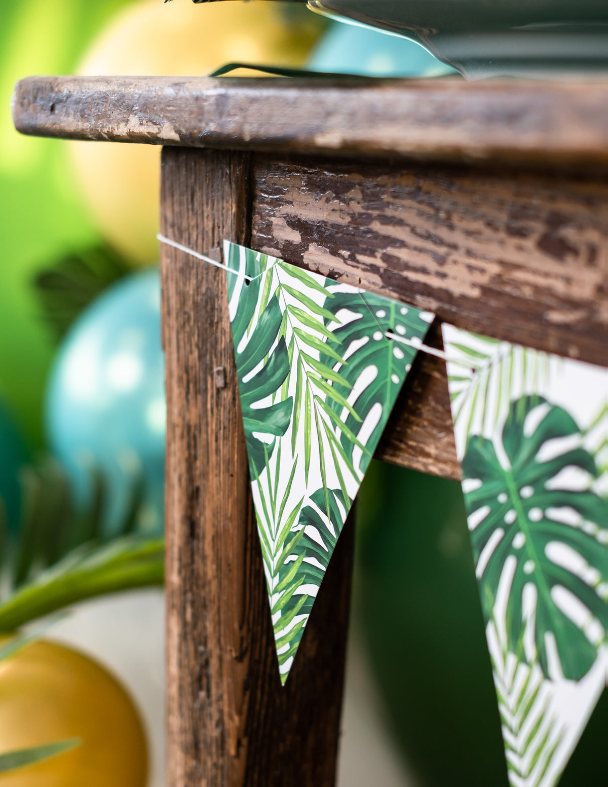 Détail d'un fanion accroché à une table de la guirlande de fanions feuilles tropicales