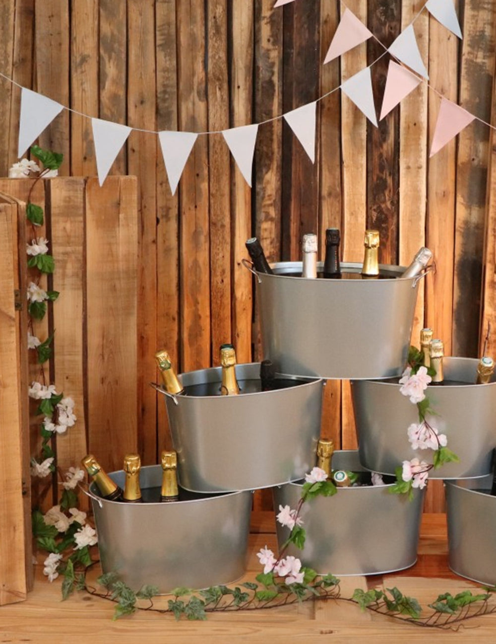 Mise en scène sur des seaux à champagne de la guirlande de fleurs de cerisier pour décoration mariage rose