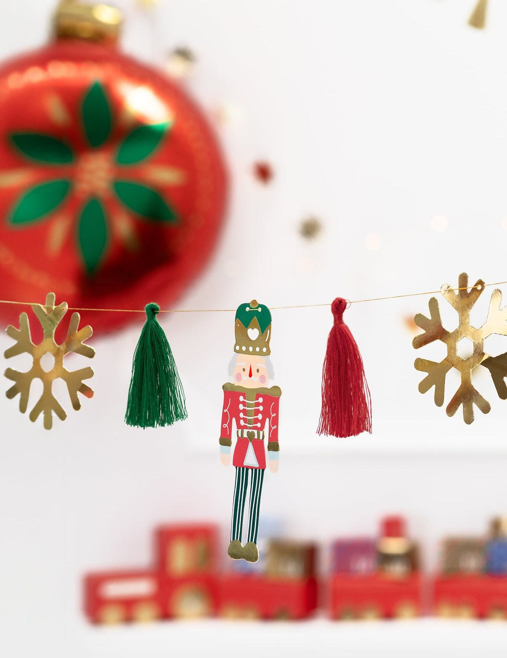 Détail du casse noisette et des pompons de la guirlande en papier casse noisette et ballerine pour noël
