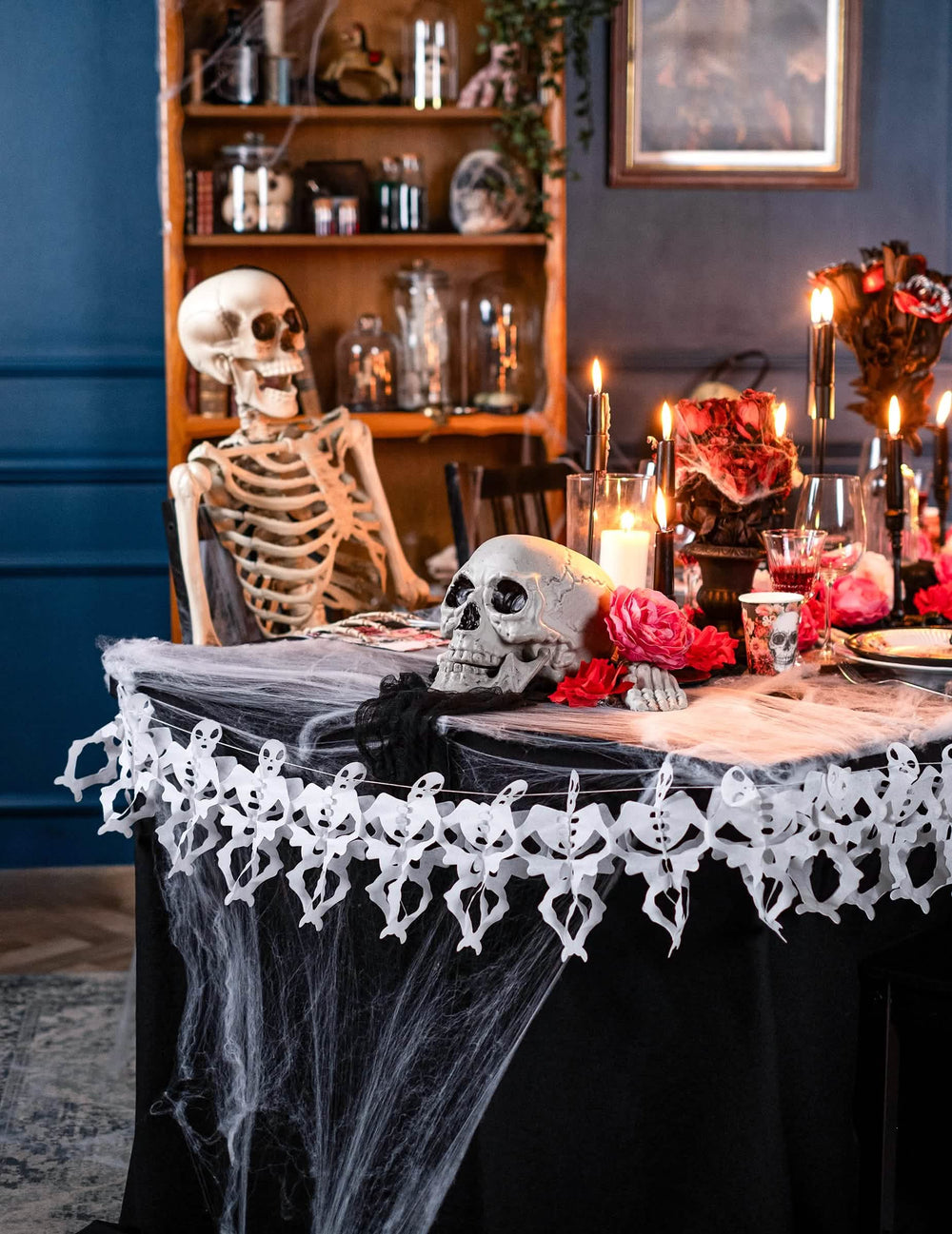 Umiestnenie papierovej girlandy s kostrou na stôl na halloween