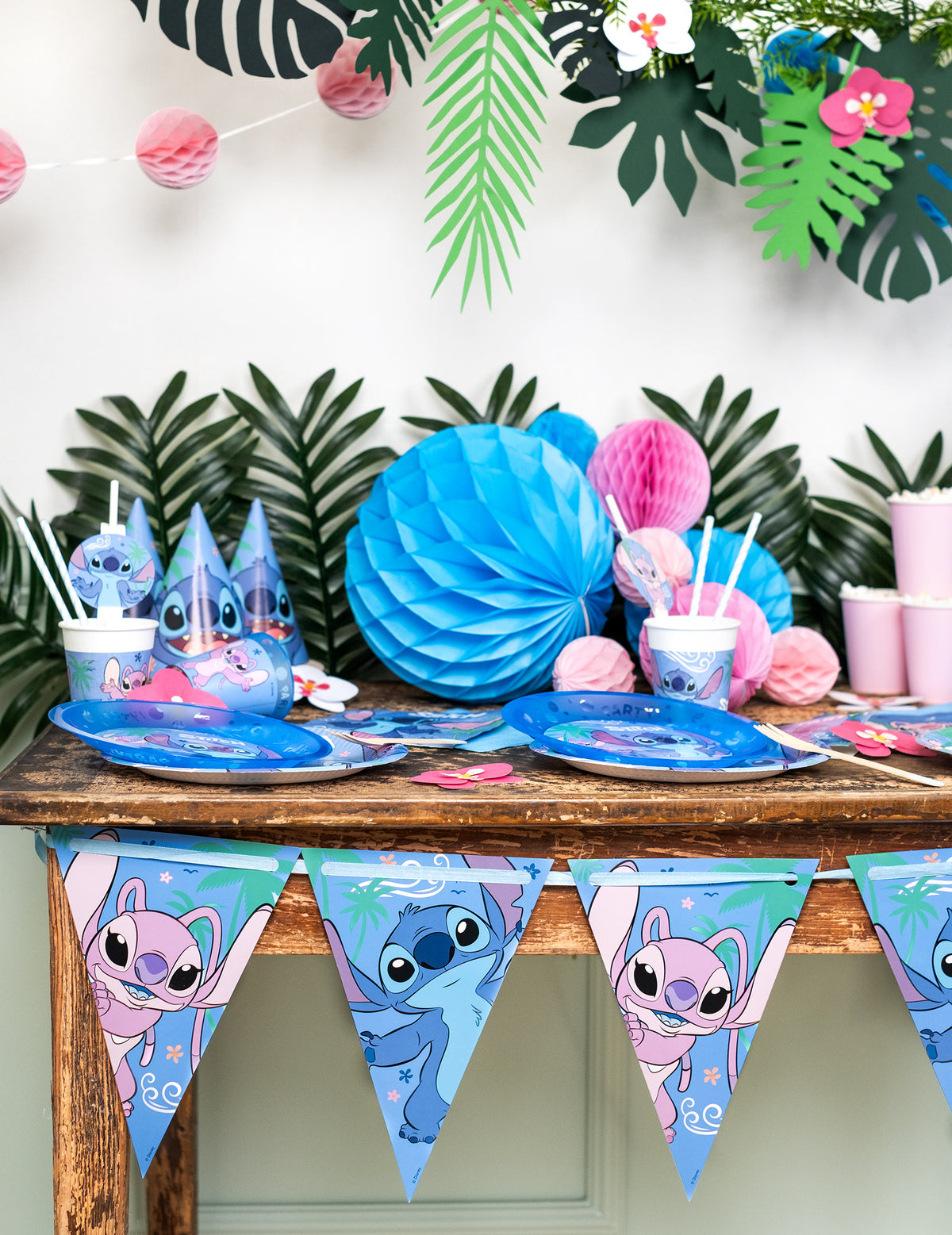 Mise en situation sur une table de fête de la guirlande fanions papier Stitch