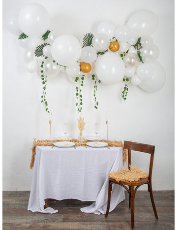 Súprava s 55 bielo-zlatými balónmi v podobe oblúka s brečtanom a tropickými listami, elegantná dekorácia.