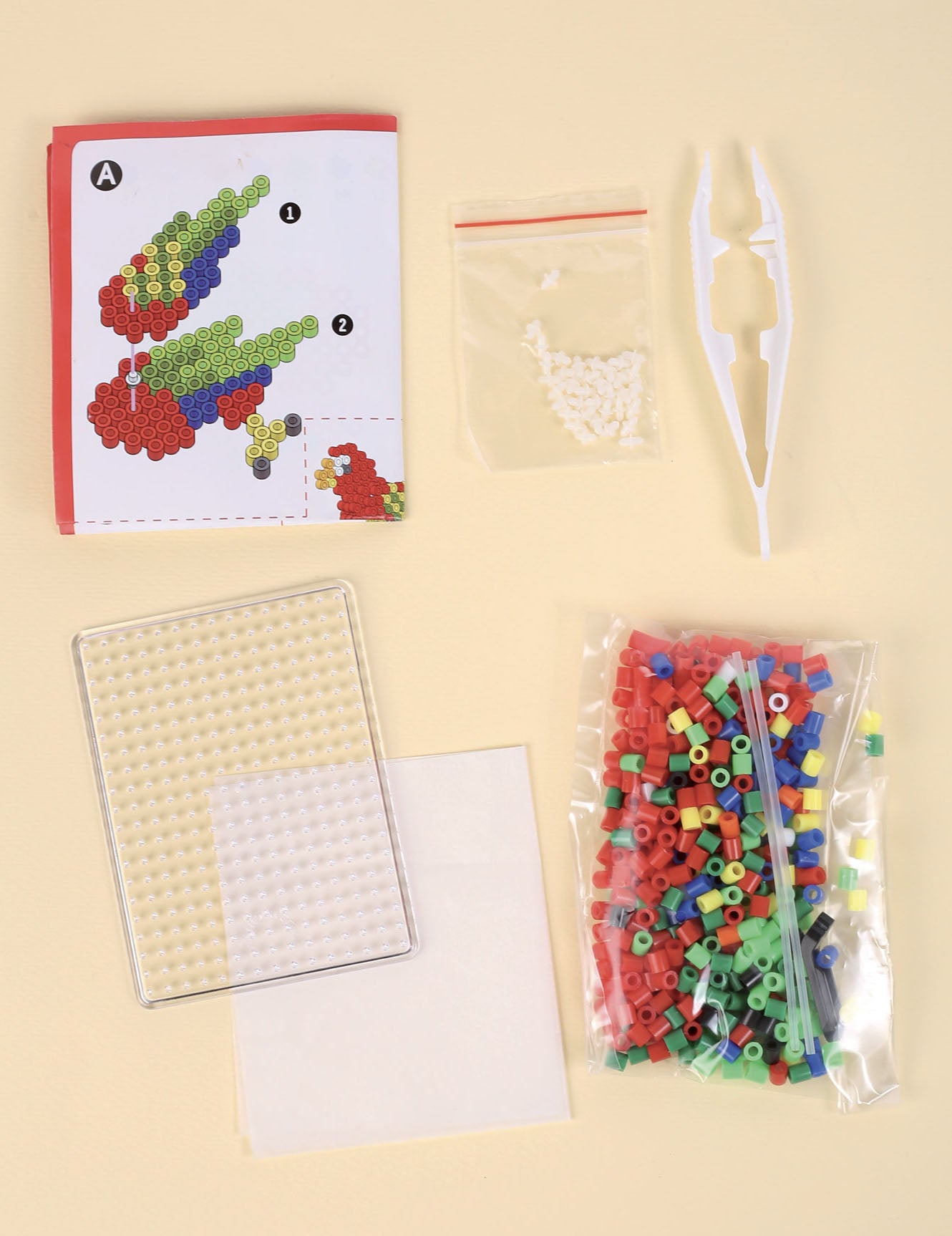 Vue du contenu et des accessoires du kit perles à repasser 3D perroquet