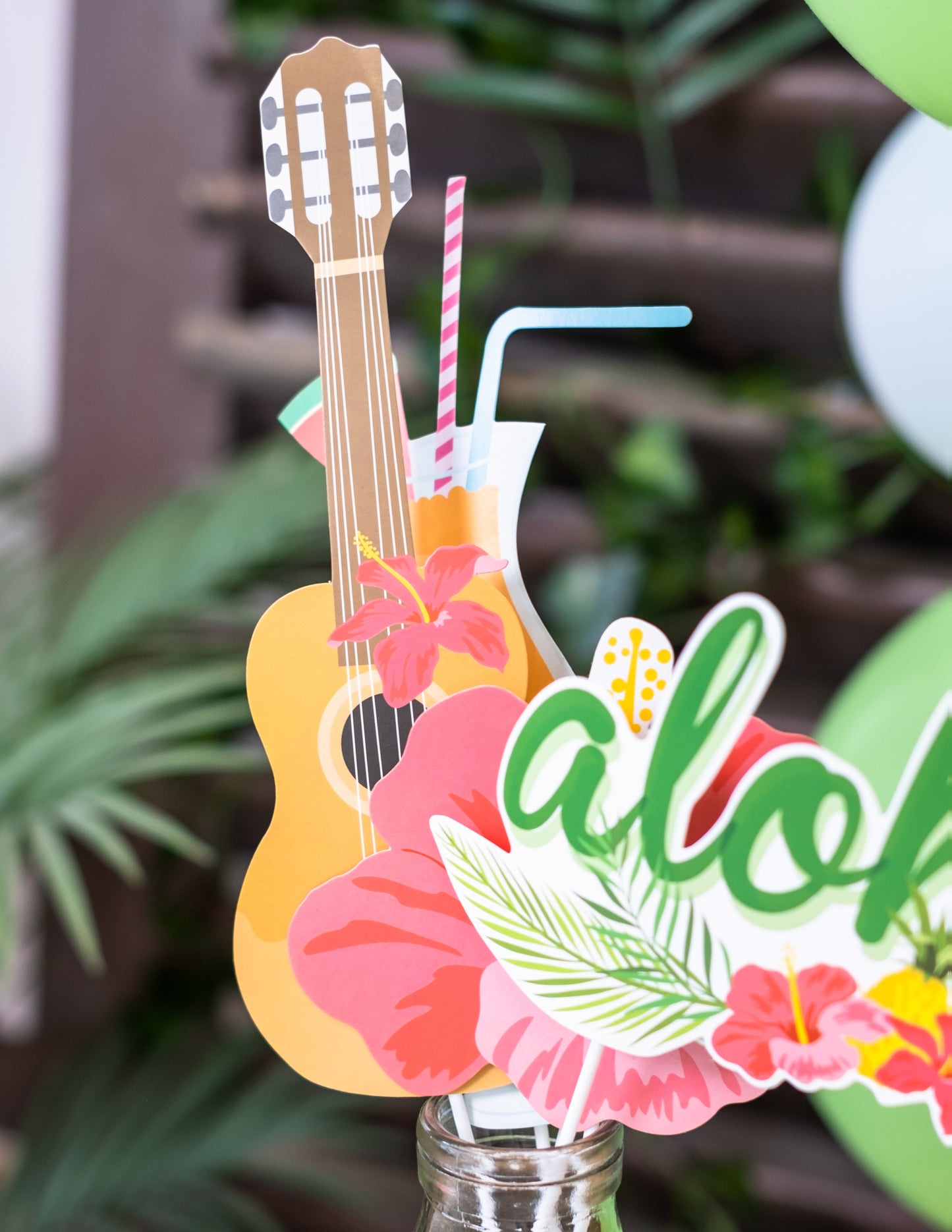 Gros plan sur les accessoires cocktail, fleurs et ukulélé du kit photobooth Hawaï