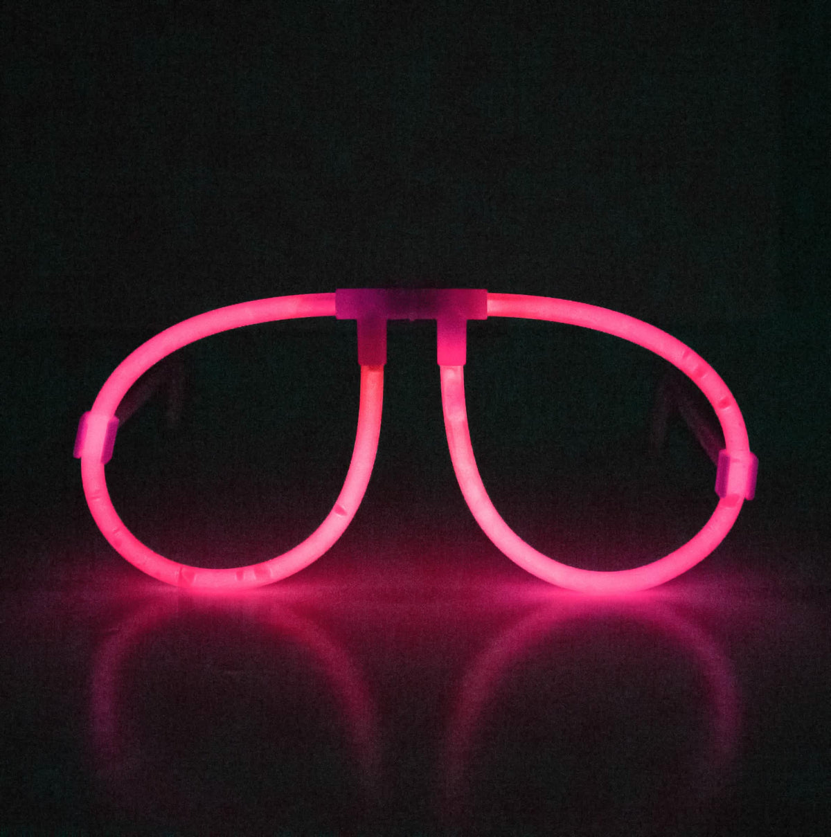 Vue de face illuminée rose des lunettes phosphorescentes fluo