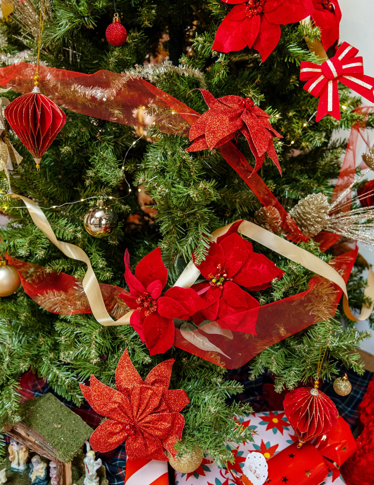 Mise en situation sur un sapin de Noël du nœud de poinsettia avec grelots pour décoration de table