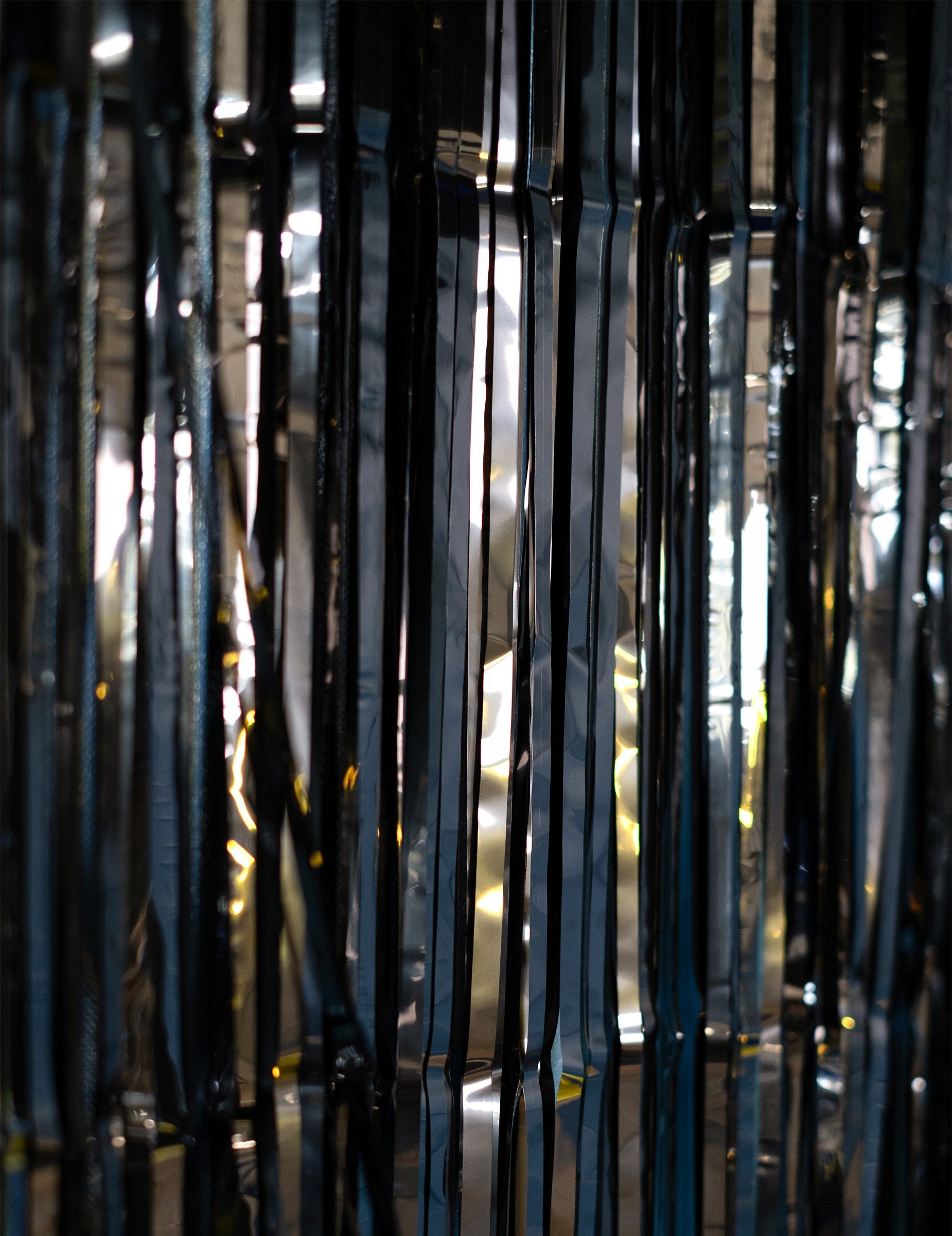 Détail des reflets sur les lamelles du rideau scintillant pour fête noir