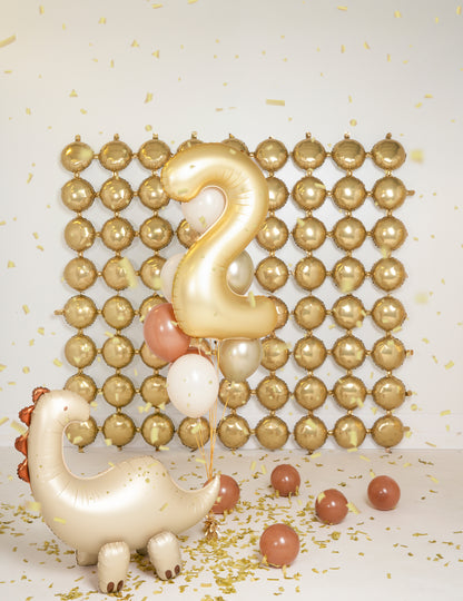 Mise en situation avec ballon chiffre 2 et dinosaure du décor en ballon aluminium double face pour fête argenté et doré