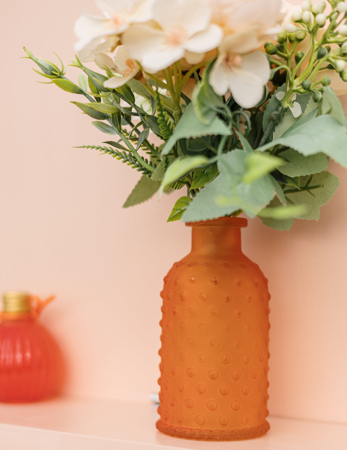 Détail de la texture et du bouquet du vase en verre texturé à pois en relief orange